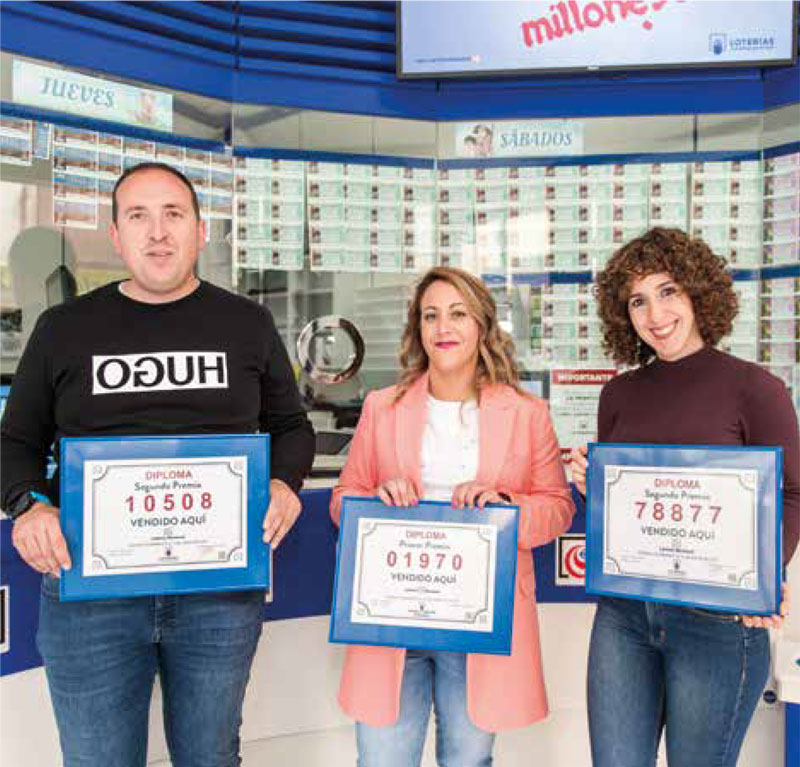 Empleados de Loterias Lazarillo sosteniendo premios de loteria